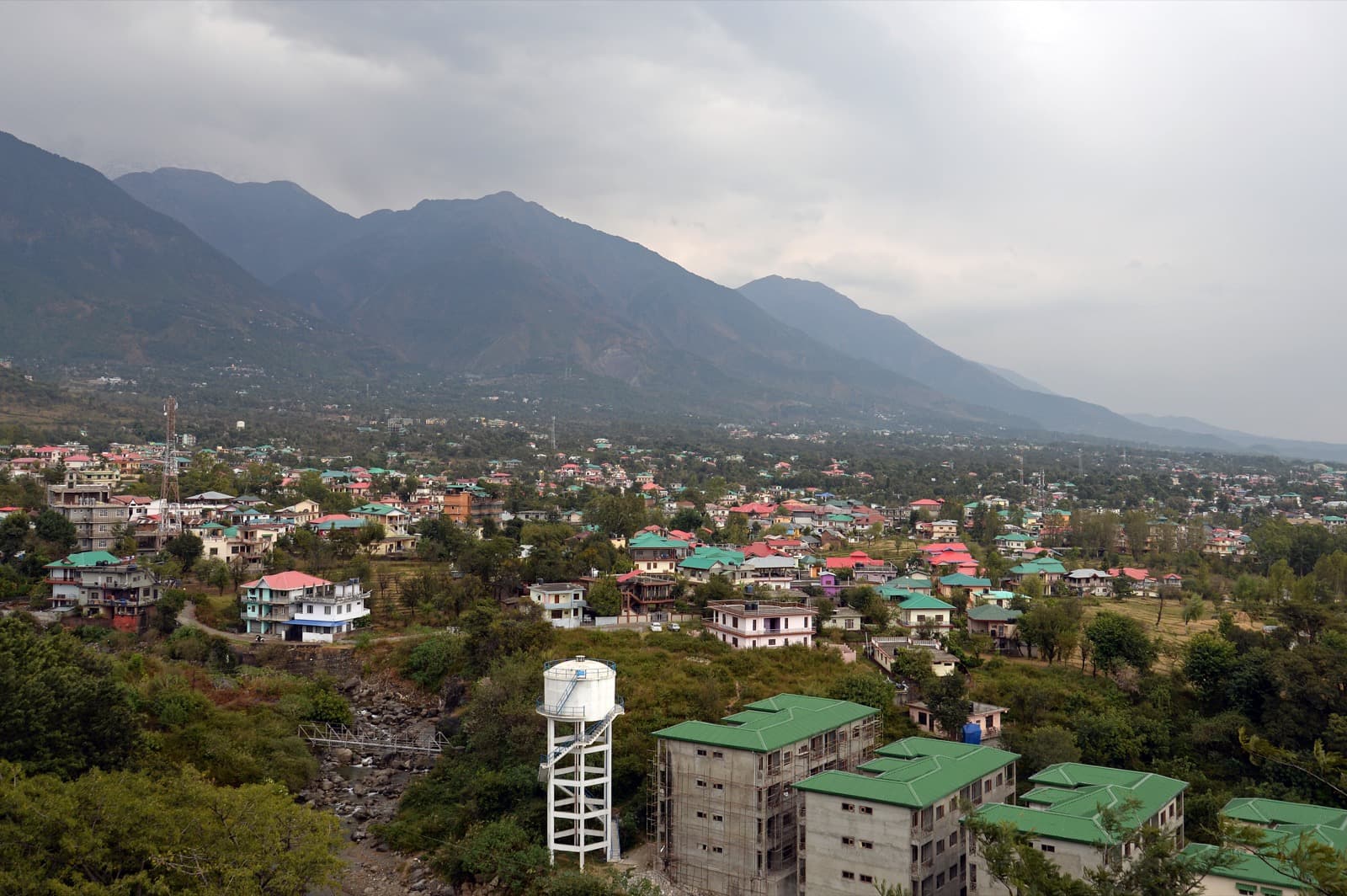 View over Dharamshala rooftops with the Dhauladhar range behind